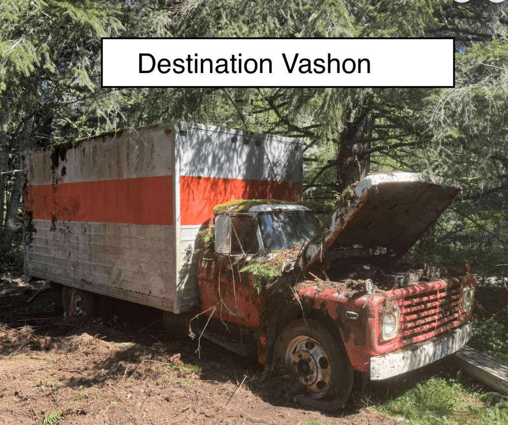 image | Vashon Maury Island Abandoned rusty truck with a large white cargo trailer in a wooded area; hood raised and plants growing around it.